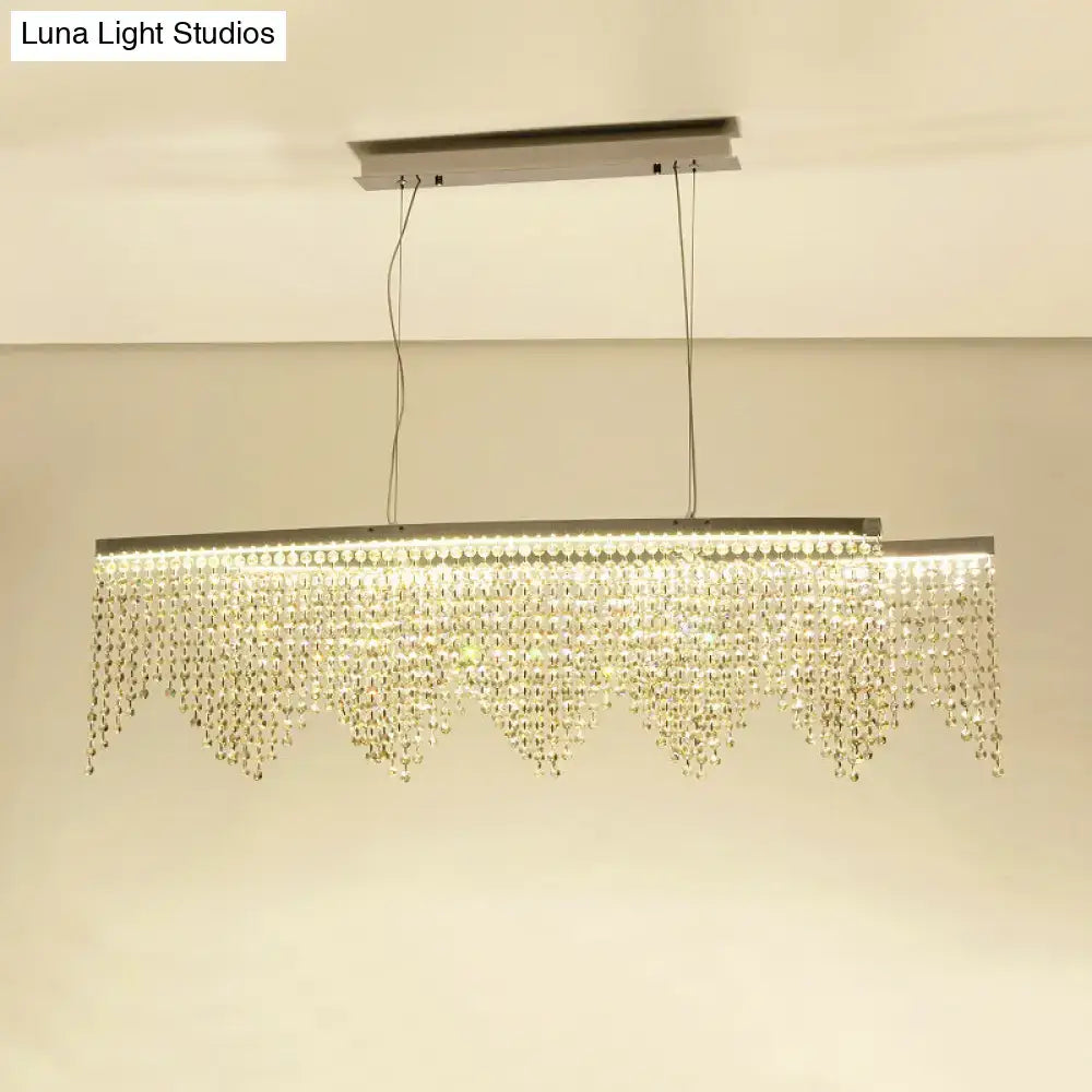 A modern silver crystal island pendant chandelier with a sleek metallic frame and clear crystal beads for dining room