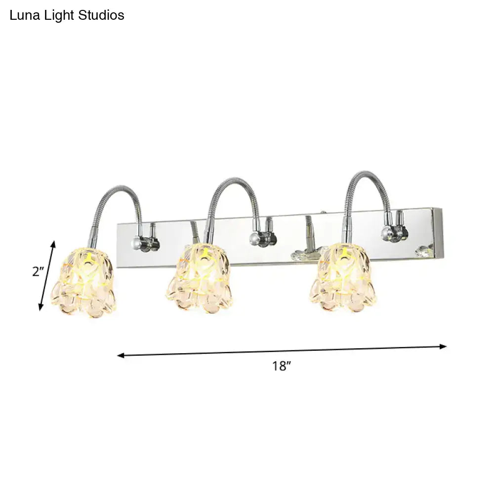 Modern silver crystal petal gooseneck arm vanity light with chrome finish and three textured glass lampshades emitting warm yellow light