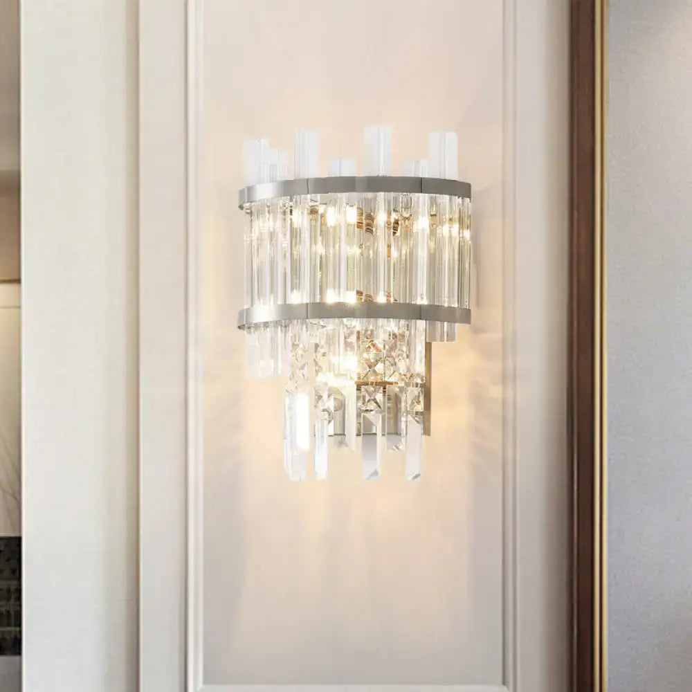 Modern silver crystal tiered wall mounted wall light with sleek metal frame and cascading faceted crystals emitting warm light