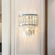 Modern silver crystal tiered wall mounted wall light with sleek metal frame and cascading faceted crystals emitting warm light