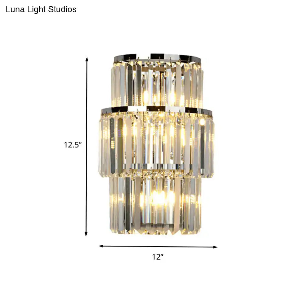 Modern silver crystal wall mounted light featuring a three-tiered crystal chandelier with chrome mounted light accents