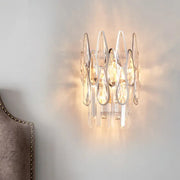 Modern silver crystal wall sconce with circular clear teardrop crystals and polished chrome frame for living room lighting