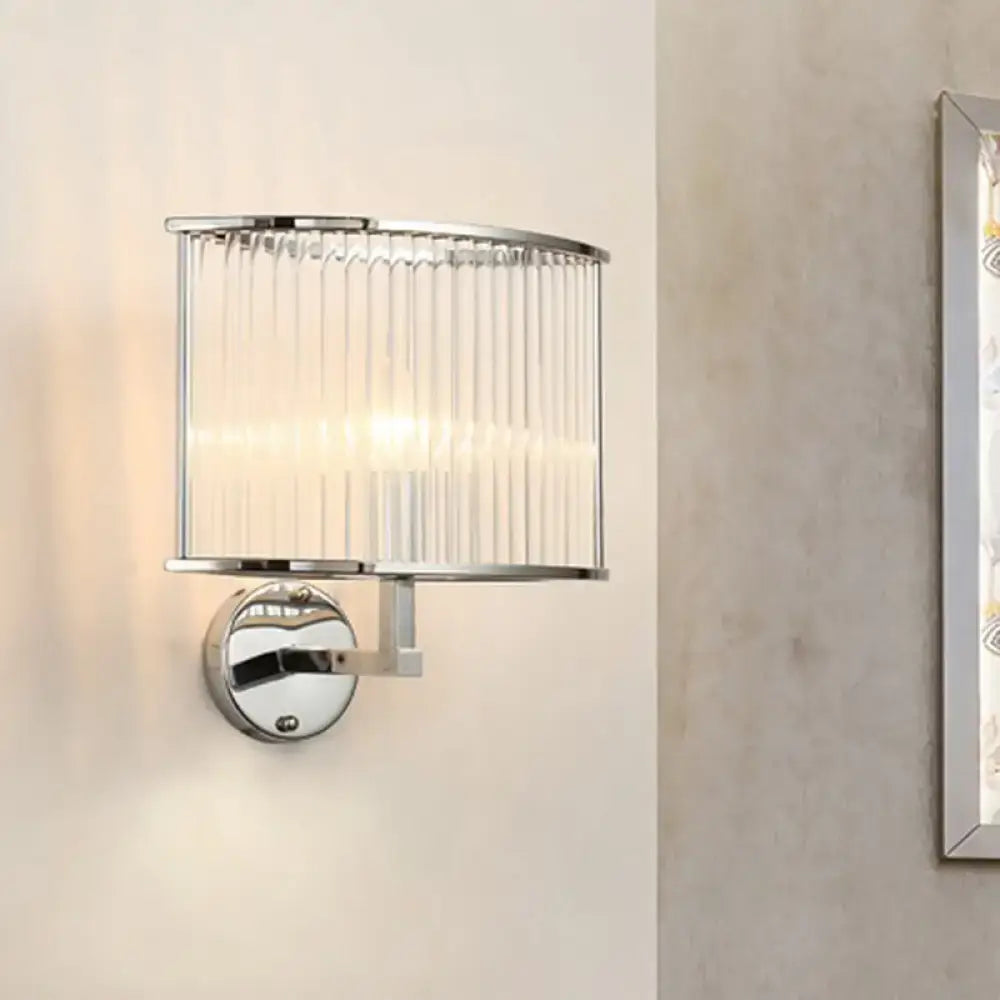 Modern wall lamp with silver finish and clear crystal cylindrical glass shade featuring vertical ridges for living room use