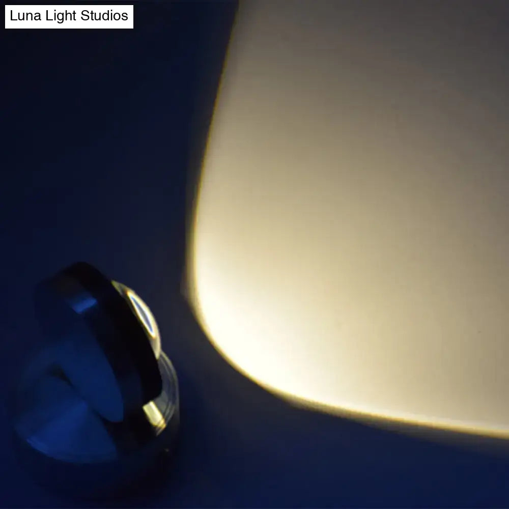 A sleek black and silver finish led spotlight with curved design for warm white lighting in bedroom wall use