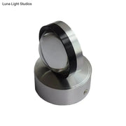 Silver finish cylindrical wall-mounted light fixture with polished metallic finish and black accent ring for bedroom wall warm white lighting