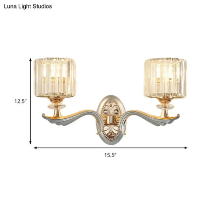 Elegant two-light flush mount wall sconce with gold and silver-toned arms, clear crystal shade, and bulb base details