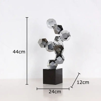 A modern silver geometric crystal ball desk ornament with interlocking faceted spheres on a black base
