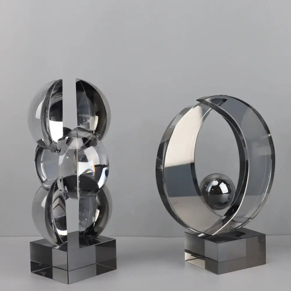 Two sleek modern geometric crystal sculptures in polished chrome and clear acrylic for home decor by decorbites