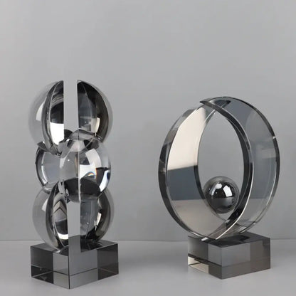 Two sleek modern geometric crystal sculptures in polished chrome and clear acrylic for home decor by decorbites