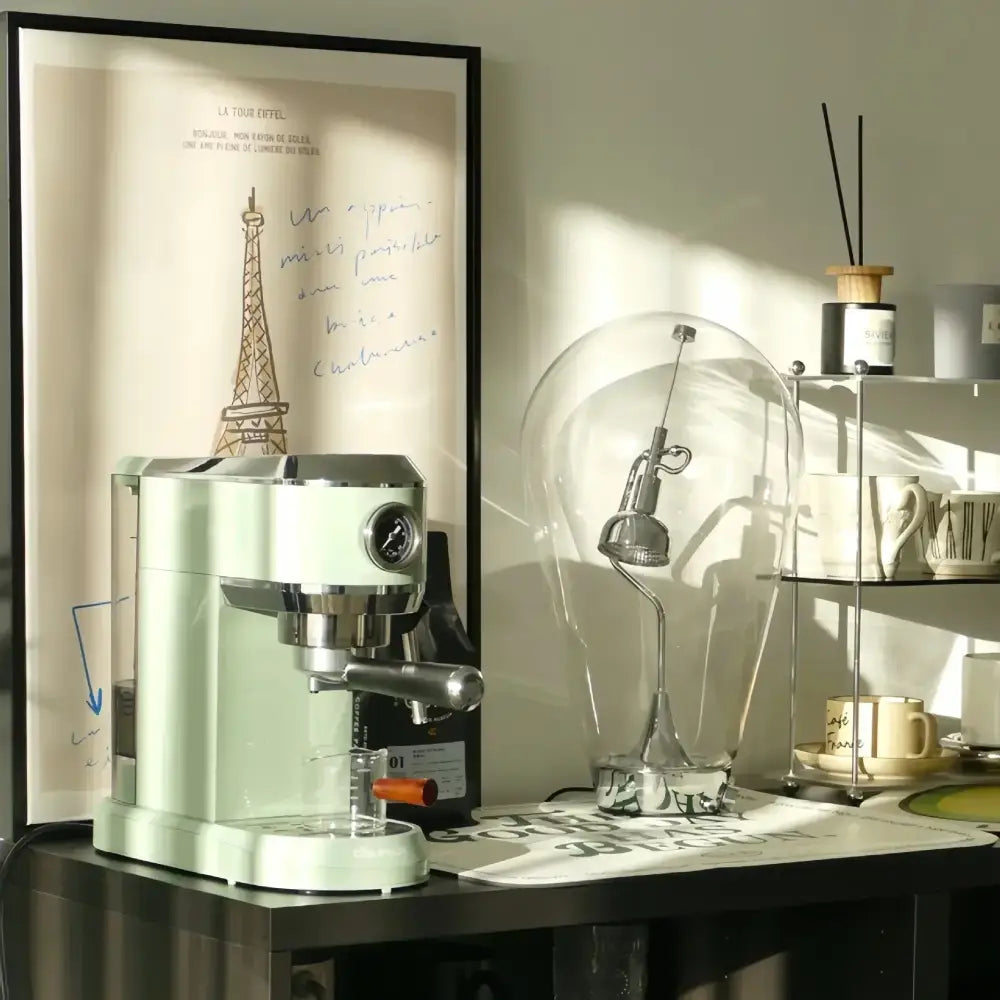 Modern silver glass desk lamp with dimmable vintage light paired with a mint green espresso machine with chrome accents and wooden handle for decorbites glass desk setup