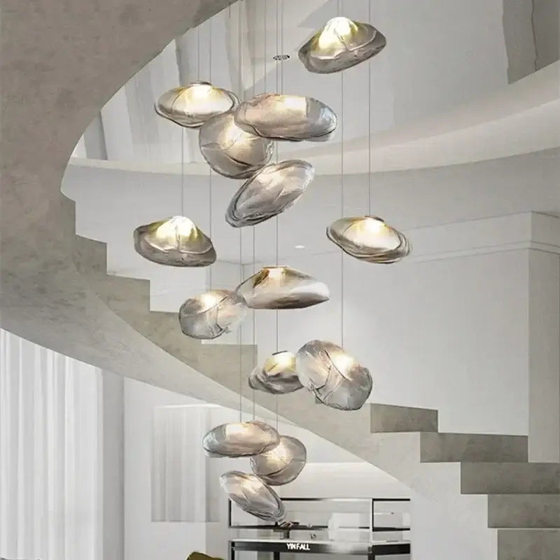 Modern silver glass led chandelier with sleek organic shell design hanging in elegant dining room arrangement