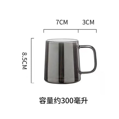 A sleek dark gray translucent glass mug with handle next to a modern silver glass water pitcher with lid for kitchen use