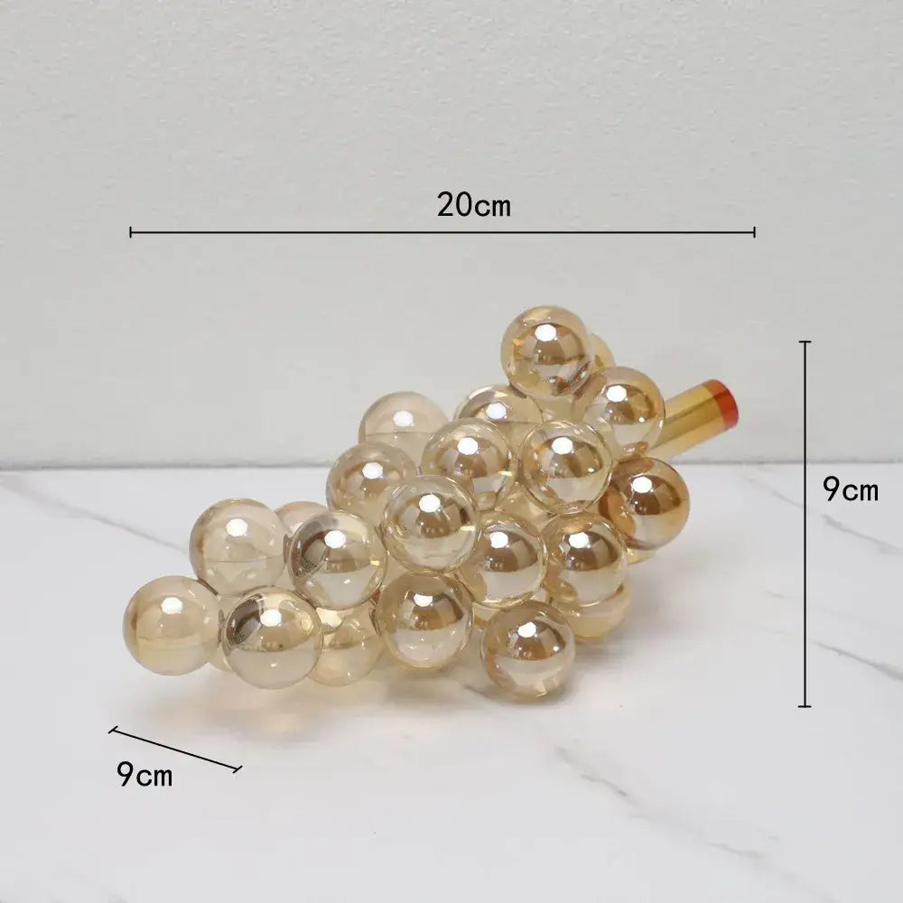 Modern silver gold and chrome crystal grape decorative sculpture featuring a translucent gold glass cluster with red stem