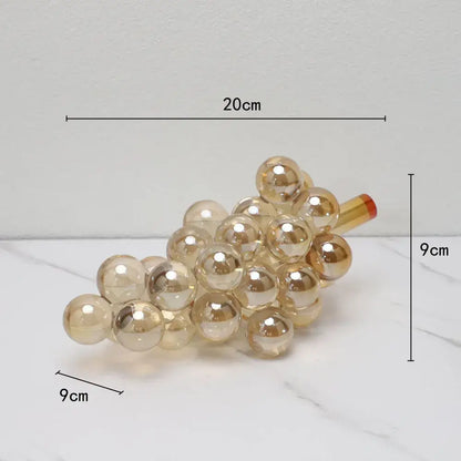 Modern silver gold and chrome crystal grape decorative sculpture featuring a translucent gold glass cluster with red stem