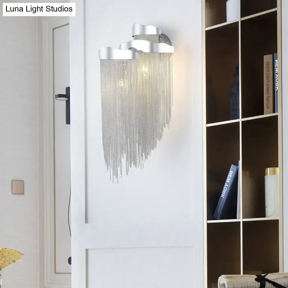 Modern silver cloud-shaped wall lamp with tassel design and bulb base featuring cascading chain fringe for bedroom use
