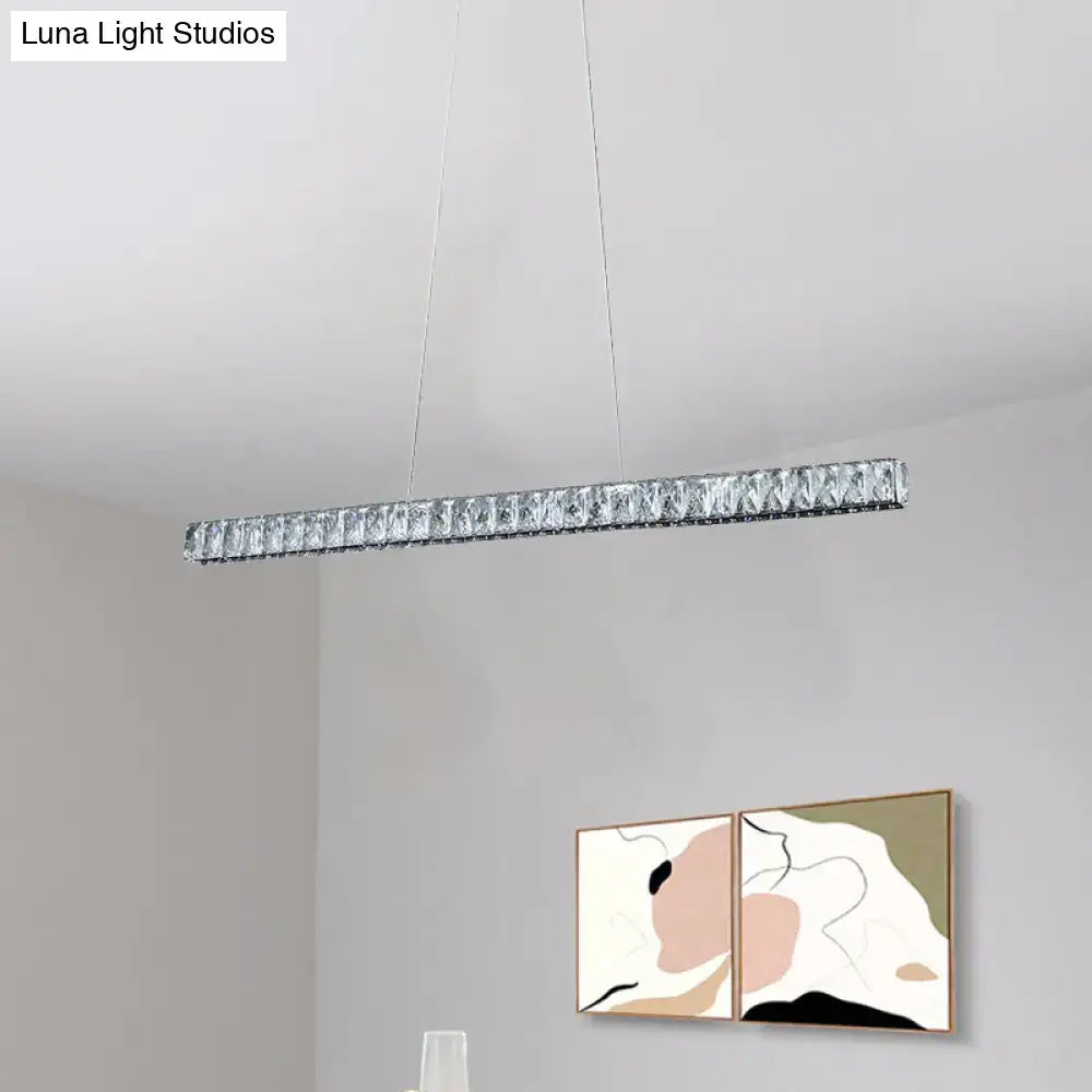 A sleek silvery linear crystal block island pendant light with clear facets for modern dining room suspension