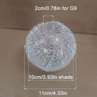 A clear, spherical stress ball with a textured, interwoven metallic mesh surface.