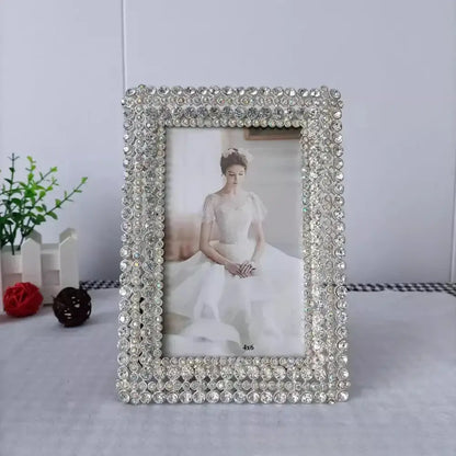 A modern silver rhinestone metal picture frame with clear faceted crystals for bedroom decor and diamond metal picture style