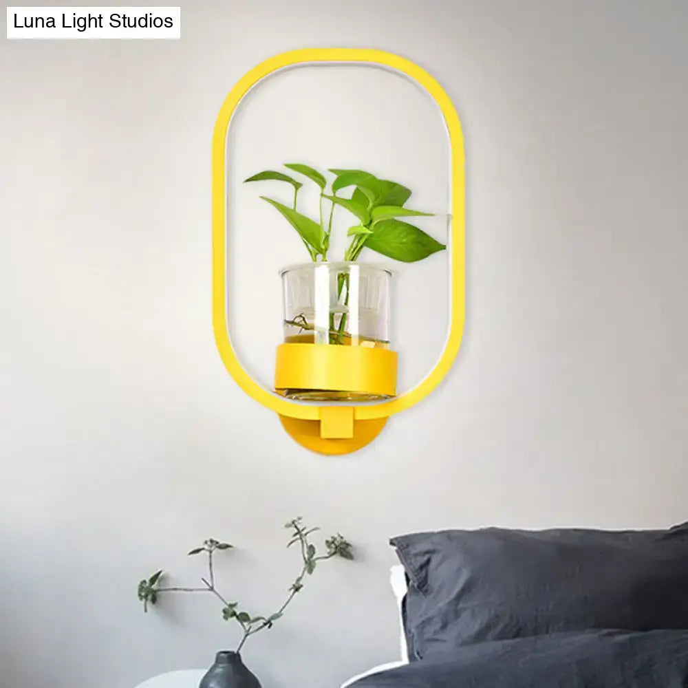 Modern silver wall light with yellow oval plant pot and clear glass container holding green plant 110v-120v