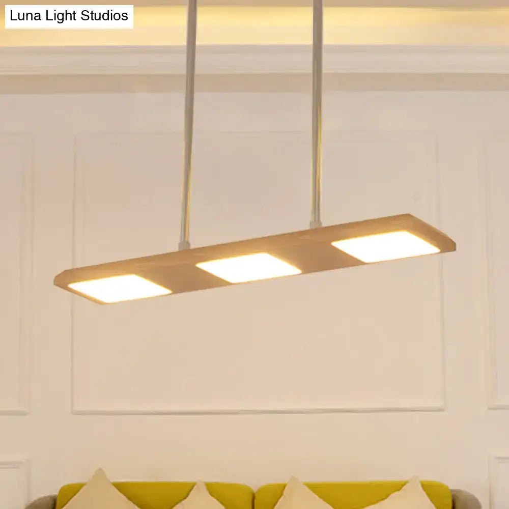 Modern simple rectangle wood island lamp with three illuminated panels in warm wood frame for dining room use