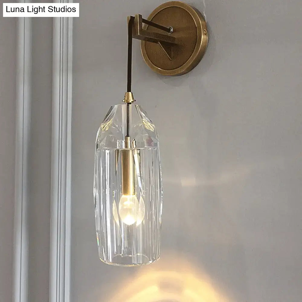 Modern single light brass wall sconce with clear crystal faceted pendant and central bulb for bedroom lighting