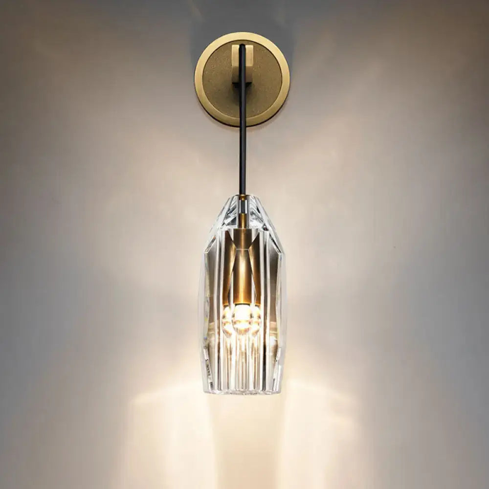 Modern single light brass wall sconce with clear crystal faceted shade and brass accents for bedroom lighting
