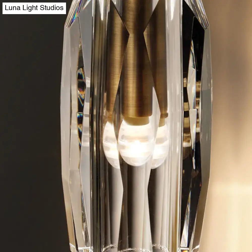 Modern single light brass wall sconce with clear crystal faceted design and gold-toned metal accents for bedroom