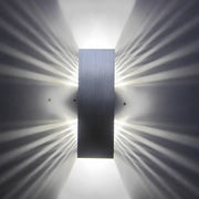 Modern slotted aluminum led wall sconce lamp with brushed metal finish emitting radiant light for living room use