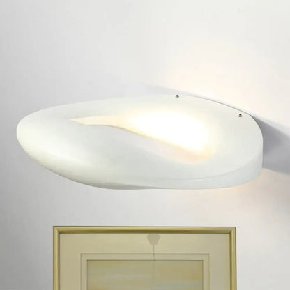 A sleek white frosted glass wall lamp with a smiling face design in black and white for modern corridors