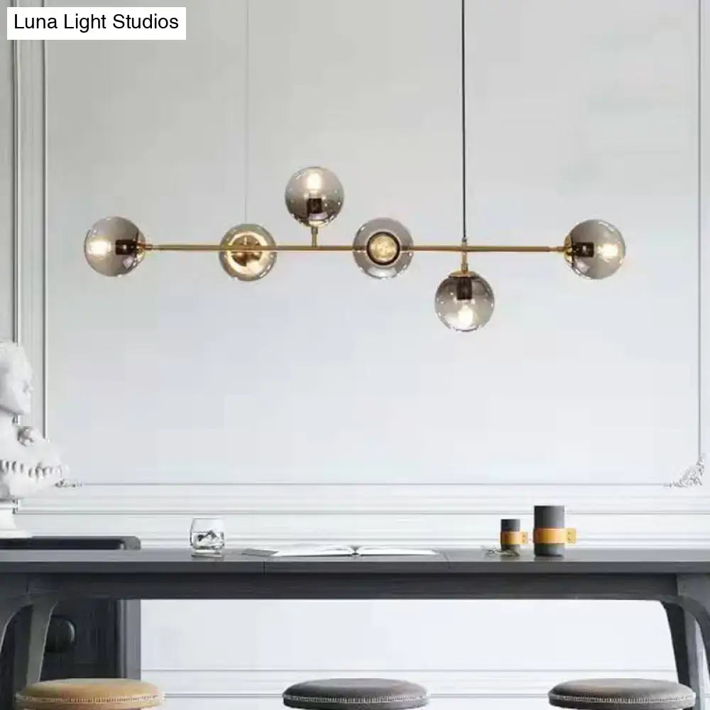 Modern brass bar pendant light with five smoked glass globe bulbs in smoke gray linear design for dining room