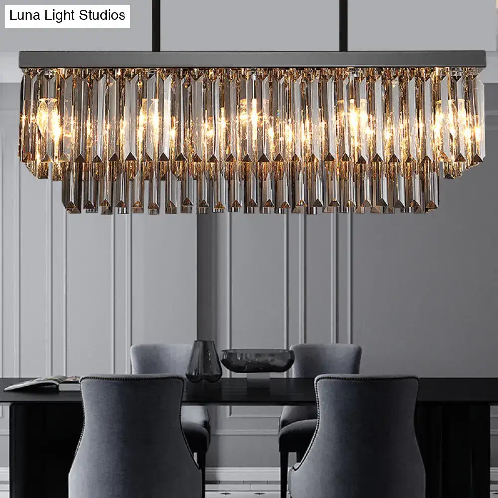 Modern smoke gray crystal rectangle chandelier with cascading golden prisms and warm glowing lights for dining room