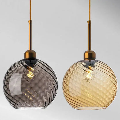 Two spherical glass chandelier pendant lights in smoky gray and amber with brass rods for modern kitchen use