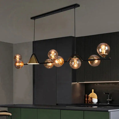 Modern black metal pendant light with smoky grey glass globes and gold-toned triangular accent for dining room
