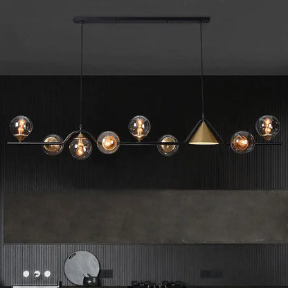 Black metal pendant light with smoky grey glass globes and central brass cone for modern dining room lighting