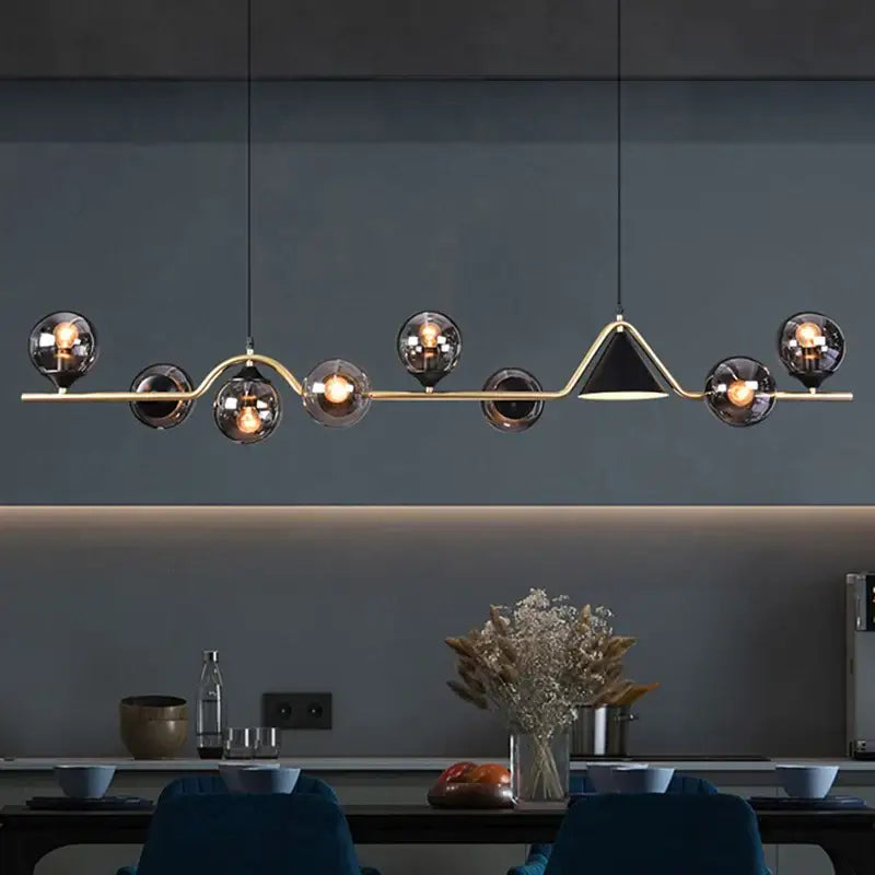 Modern pendant light with smoky grey glass bulbs and gold-toned triangular accent for dining room use