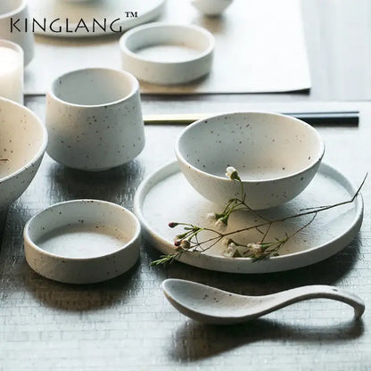 White ceramic dinner plate set with subtle speckled texture and smooth curved rim for modern dining use