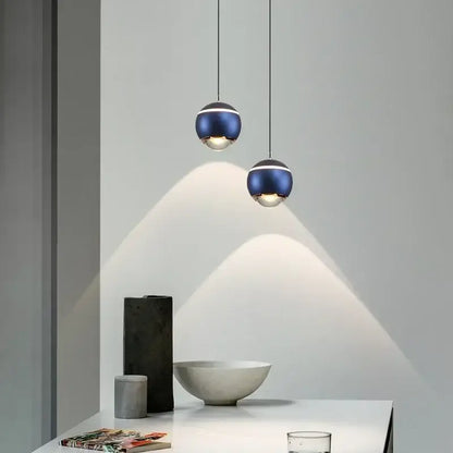 Two deep blue metallic spherical pendant lights with silver accents hang from thin cords in modern led bedside decorbites