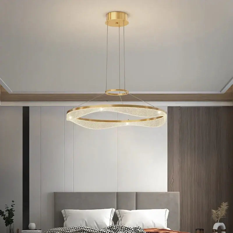 Modern spiral acrylic ring pendant light fixture with gold-toned woven mesh design and embedded LED lighting
