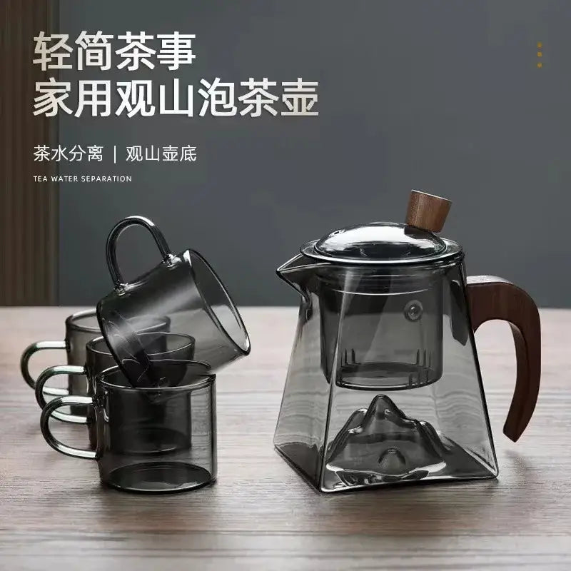 Modern square glass tea pot with transparent geometric mountain-shaped base and dark wood handle and lid knob