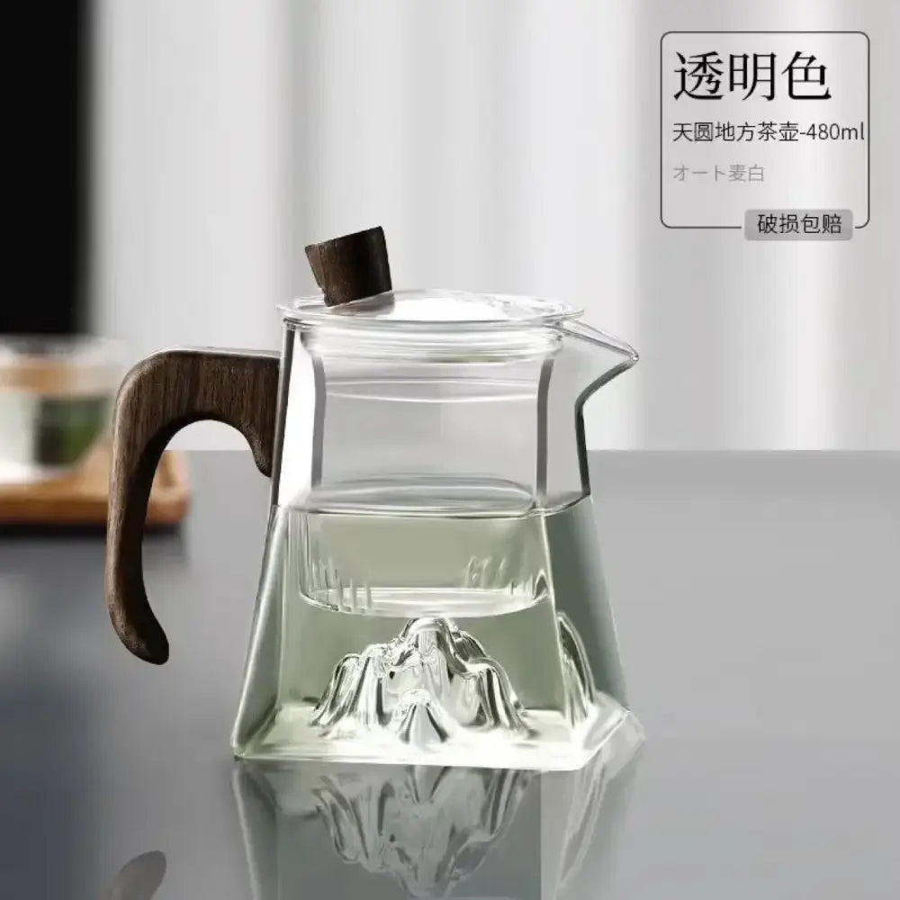 Modern square glass tea pot with dark wood handle and lid featuring an embossed mountain design at its base