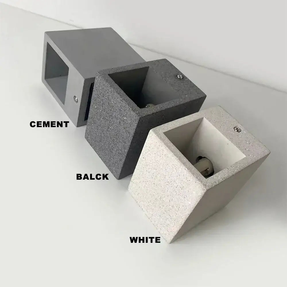 Three modern cube-shaped decorbites cement wall lamps in gray, dark charcoal, and white speckled cement finishes
