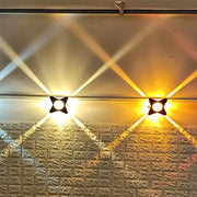 Two black star-shaped modern star petals outdoor wall sconces emit warm yellow led light on textured brick wall