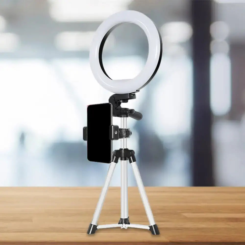 Modern style white led flash light with black phone clamp mounted on silver tripod for streaming and photography
