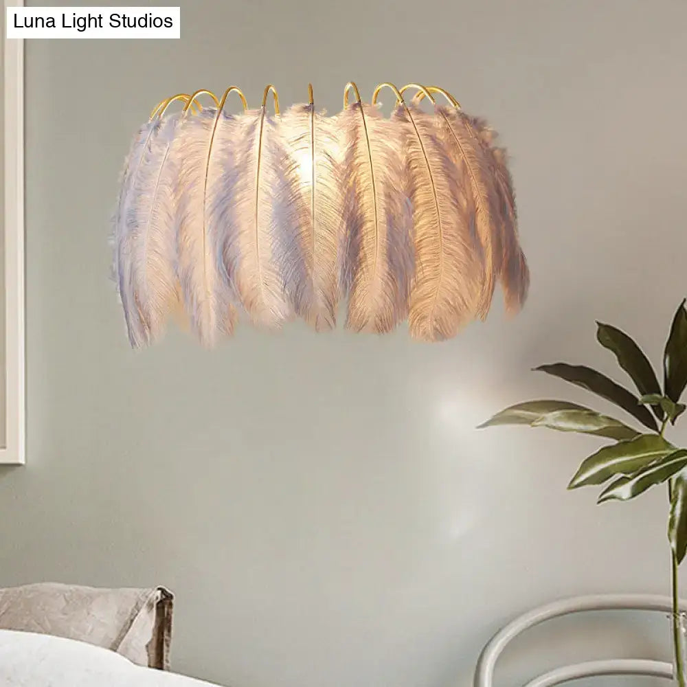 Modern style grey white sconce light with soft feathery pendant and gold-toned metal frame for wall decor