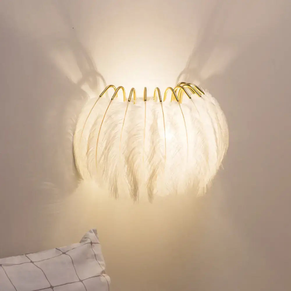 Modern style grey white feather sconce light with soft glowing white feather and delicate gold wire frame wall decor