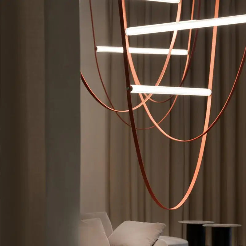 Modern tan leather and brass led tube suspension chandelier with copper-toned strap and curved bars for living room