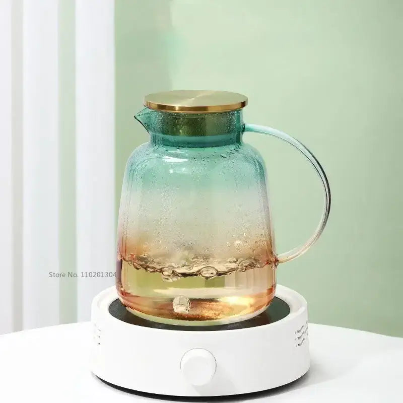 Modern teal and gold glass teapot set with gradient glass teapot and gold lid on white electric heating base