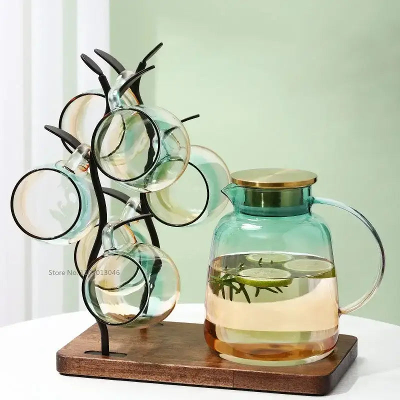 Modern teal and gold glass teapot set featuring a glass pitcher with gold lid and handle filled with infused water