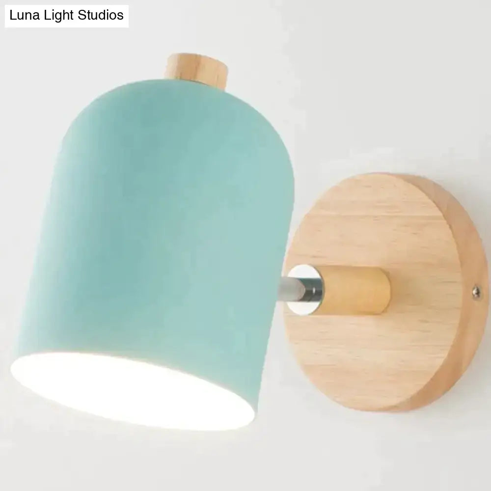 Modern teal and wood wall lamp with a mint green ceramic lampshade and natural wood base for bedroom use