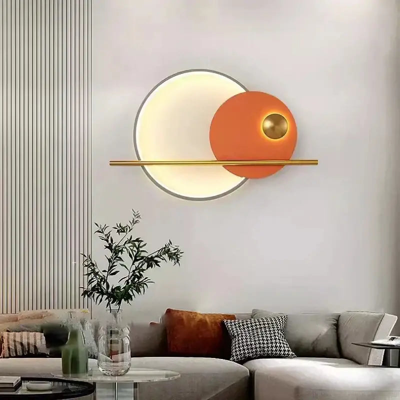 Modern teal and gold led wall sconce with a warm white illuminated ring and orange accent disc in colorful metal design